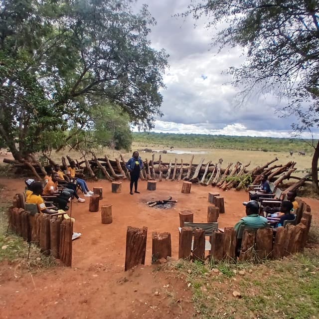 A group seated in an outdoor discussion circle