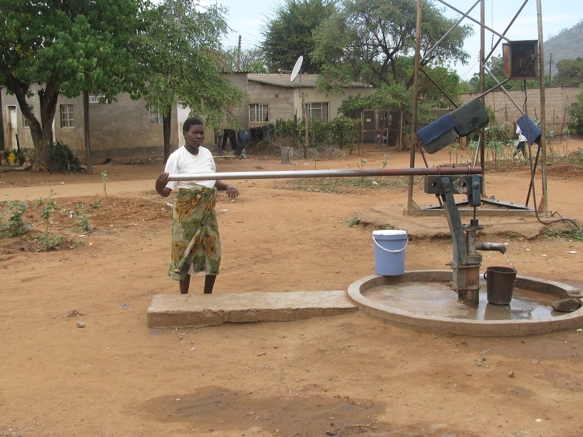 A woman pumping water at a community well